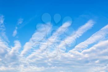 view of blue sky with clouds shaped as spread fingers in sunny autumn day