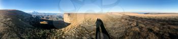 travel to North Caucasus region region - shadows of people in panorama of Bermamyt mountain Plateau at september morning
