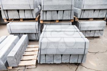 stockpiles of new gray concrete curbs for road repairing