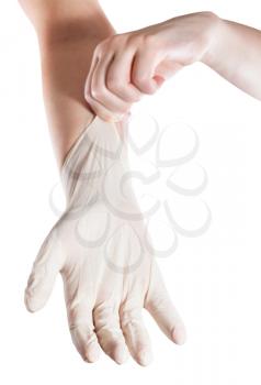 female hand pulls latex glove on another hand isolated on white background