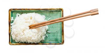 top view of boiled rice with chopsticks on green plate isolated on white background