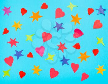 many stars and hearts cut from colour papers on blue turquoise pastel paper