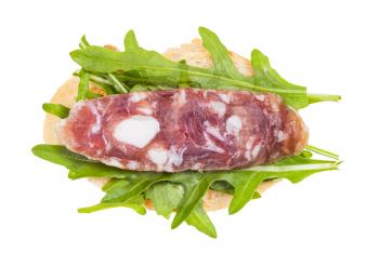 top view of open sandwich with fresh bread, cured sausage and green arugula leaves isolated on white background