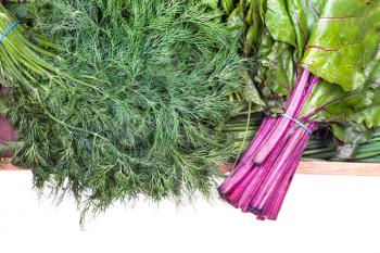 top view of bundles of beet tops and fresh dill close-up on wooden tray isolated on white background