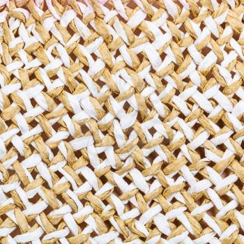 textile square background - texture of summer straw hat from interwoven toyo fibers close up