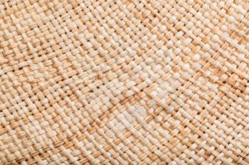 textile background - texture of summer straw hat from natural raffia fibers close up