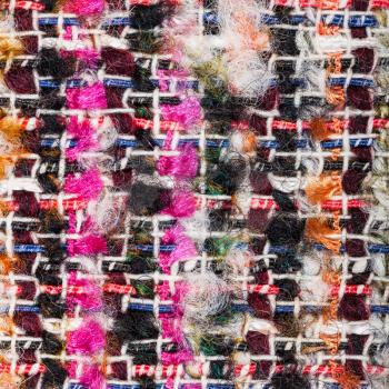 textile square background - weaving of color threads in boucle fabric close up