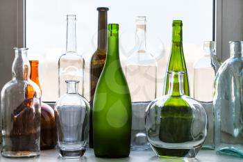 various empty bottles on windowsill at home on sunny spring day