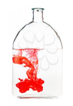 red ink dissolves in water in bottle isolated on white background