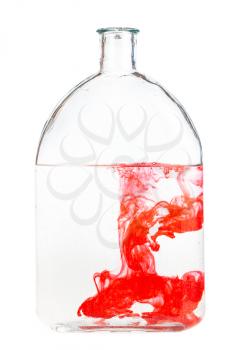red watercolour dissolves in water in glass flask isolated on white background