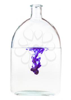 violet ink dissolves in water in glass flask isolated on white background