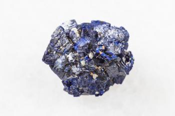 macro photography of sample of natural mineral from geological collection - raw Azurite mineral crystals from Jezkazgan, Kazakhstan on white marble background