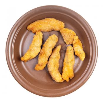 top view of several chicken strips (breaded and deep fried pieces of chicken meat) on brown plate isolated on white background
