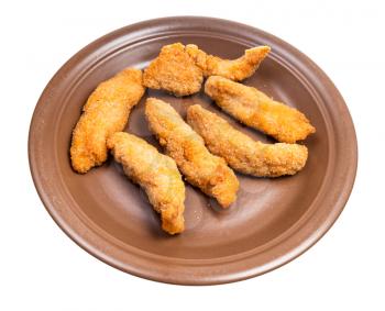 several chicken strips (breaded and deep fried pieces of chicken meat) on brown plate isolated on white background