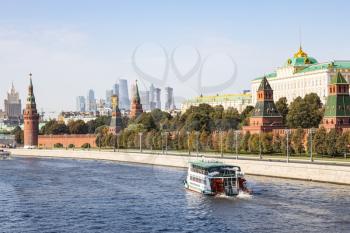 boat in Moskva river near Kremlin and view of Moscow-city and skyscraper of Ministry of Foreign Affairs on horizon from Bolshoy Moskvoretsky Bridge on sunny autumn day