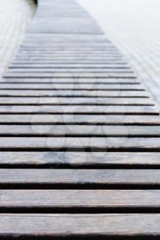 wooden planks of long outdoor bench on autumn day (focus on foreground)