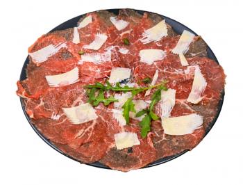 served Carpaccio (thinly sliced raw beef fillet) decorated by Parmesan, Arugula and capers on black plate isolated on white background