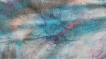 textile background - detail of hand-colored abstract batik on cotton fabric