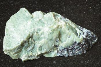 natural mineral from geological collection - unpolished Teisky Jade (Hantigyrite, khakassian serpentine) rock with Magnetite, Serpentine, Hematite minerals from Teyskoye, Khakassia on black granite