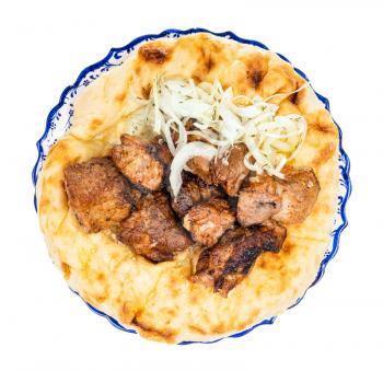 top view of portion of kebab on flatbread on plate isolated on white background