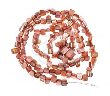 top view of tangled string of beads from natural pink pieces of mother-of-pearl isolated on white background