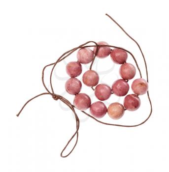 top view of coiled string of beads from natural polished pink rhodonite gemstone isolated on white background