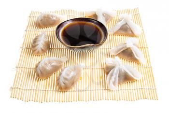 chinese cuisine - various Dim sum and soy sauce in bowl on wooden mat isolated on white background