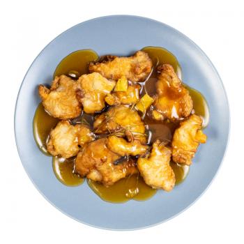 chinese cuisine - top view of pork in orange sauce (sliced pork tenderloin fried in batter with orange sauce and garnished with cilantro) on blue plate isolated on white background