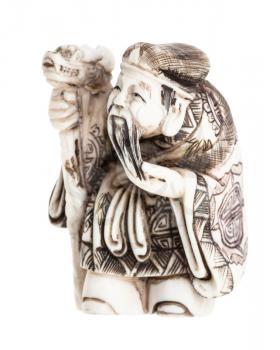 antique japanese netsuke - old man with staff carved from ivory isolated on white background