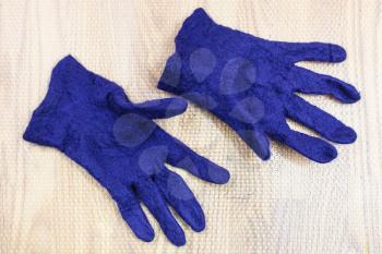 workshop of hand making a fleece gloves from blue Merino sheep wool using wet felting process - finished wet felted gloves after fulling