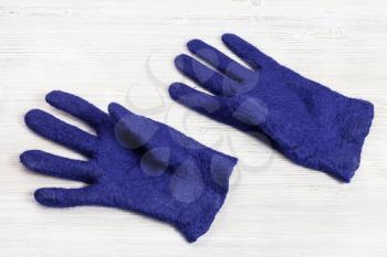 workshop of hand making a fleece gloves from blue Merino sheep wool using wet felting process - finished woolen felted gloves after drying