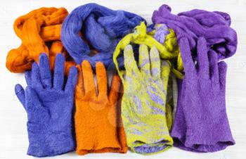 workshop of hand making a fleece gloves from sheep wool using wet felting process - multi coloured woolen handmade felted gloves and wools for them