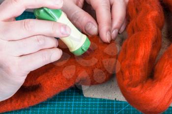 master class of repairing fleece glove using Needle felting process - craftsman poking felt with felting punch close up