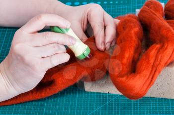 master class of repairing fleece glove using Needle felting process - craftsman binding fibers in felt with felting punch