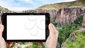 travel concept - tourist photographs of Ihlara Valley of Aksaray Province in Cappadocia in spring in Turkey on smartphone with empty cutout screen with blank place for advertising