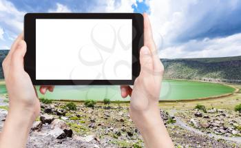 travel concept - tourist photographs of Narligol Crater Lake (Lake Nar) in Geothermal Field in Aksaray Province of Cappadocia Turkey on smartphone with cutout screen with blank place for advertising