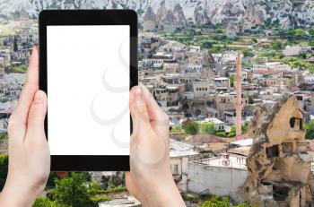 travel concept - tourist photographs of skyline of Goreme town in Cappadocia in spring in Turkey on smartphone with empty cutout screen with blank place for advertising