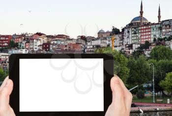 travel concept - tourist photographs of Fatih district in Istanbul city in Turkey in spring evening on smartphone with empty cutout screen with blank place for advertising