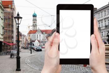 travel concept - tourist photographs of Maximilianstrasse and view of Basilica SS Ulrich and St Afra in Augsburg town in Germany on smartphone with empty cutout screen with blank place for advertising