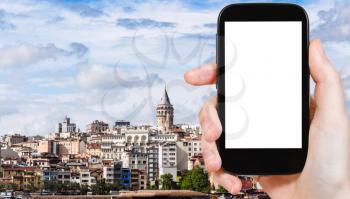 travel concept - tourist photographs of Galata (Karakoy) District with Tower in Istanbul city in Turkey on smartphone with empty cutout screen with blank place for advertising