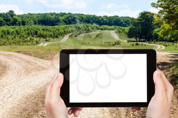 travel concept - tourist photographs of country roads in Abinsk Foothills of Caucasus Mountains in Kuban region of Russia on smartphone with cut out screen with blank place for advertising