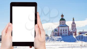 travel concept - tourist photographs of Suzdal town with Church of Elijah the Prophet on Ivanovo Hill (Elijah Church) in winter on smartphone with cutout screen with blank place for advertising