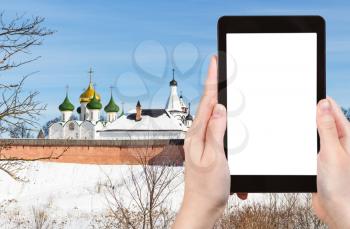 travel concept - tourist photographs of Monastery St Euthymius with Cathedral of Transfiguration of the Saviour in Suzdal of Russia on smartphone with cutout screen with blank place for advertising