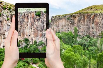 travel concept - tourist photographs of gorge of Ihlara Valley in Aksaray Province in Cappadocia on smartphone in Turkey in spring