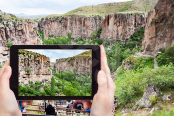 travel concept - tourist photographs of natural gorge of Ihlara river Valley in Aksaray Province in Cappadocia on smartphone in Turkey in spring