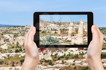travel concept - tourist photographs of mountain landscape in Goreme National Park in Cappadocia on smartphone in Turkey in spring