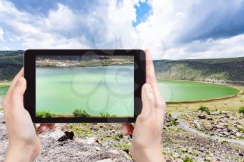 travel concept - tourist photographs of Narligol Crater Lake (Lake Nar) in Geothermal Field in Aksaray Province of Cappadocia on smartphone in Turkey in spring