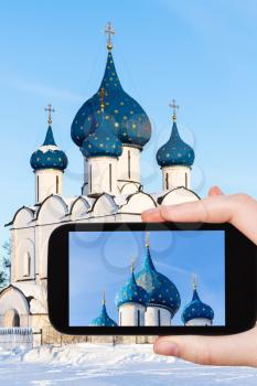 travel concept - tourist photographs of Cathedral of Nativity of the Virgin ( The Cathedral of the Nativity of the Theotokos) in Suzdal Kremlin in Russia on smartphone in winter