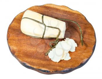 sliced local italian Provola Affumicata (smoked provola) cheese on dark wooden cutting board isolated on white background