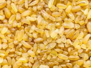 food background - bulgur (burghul) groats, parboiled and crushed wheat grains close up